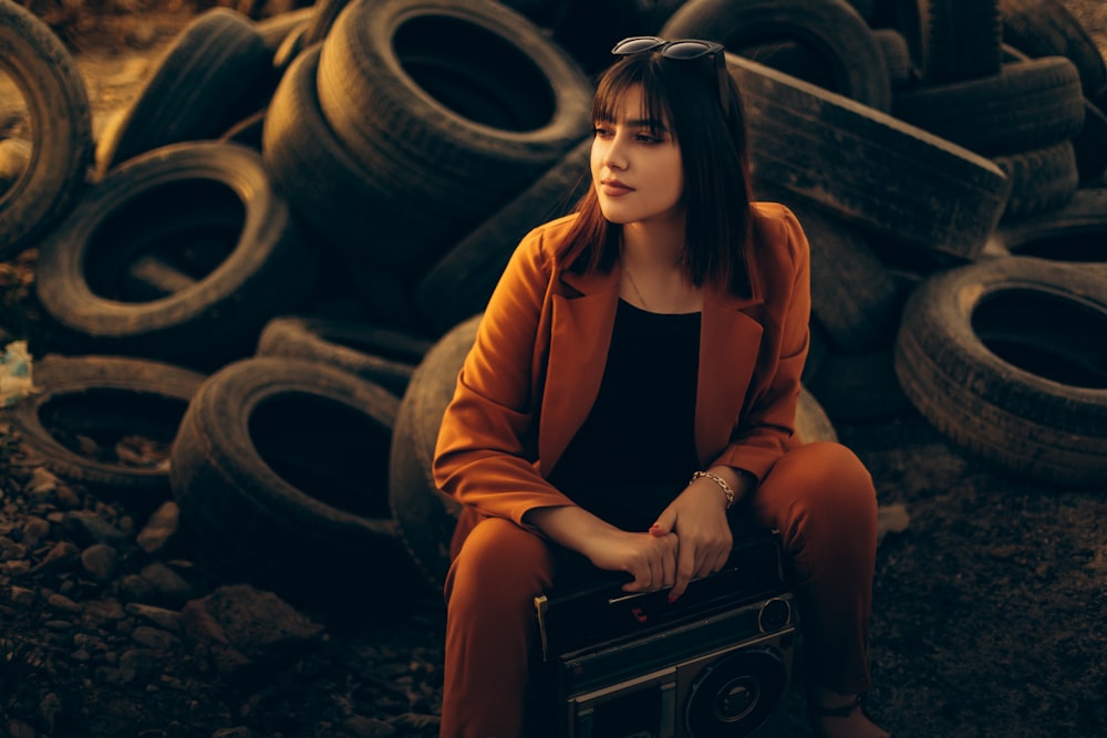 a woman sitting on a pile of tires