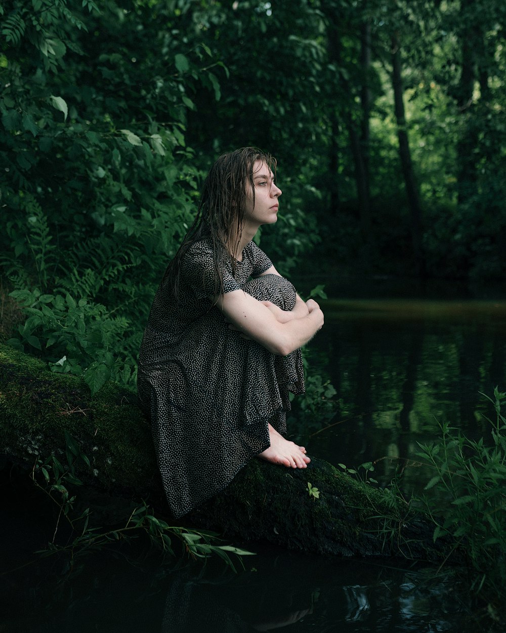 a person standing in a body of water with trees in the back