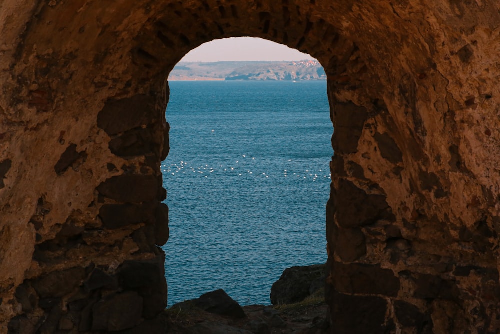 a view of the ocean from a stone archway