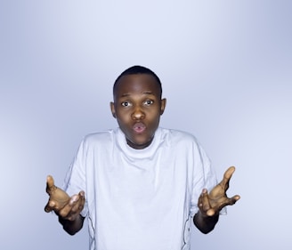 a young boy holding his hands up gesturing 'what'