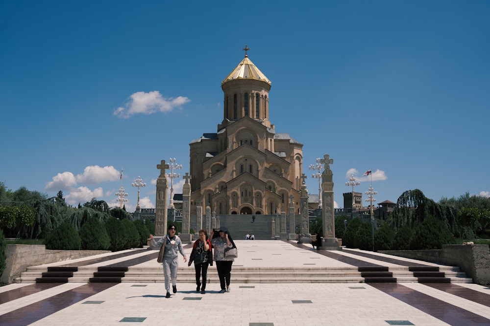 a group of people walking towards a building with a gold roof