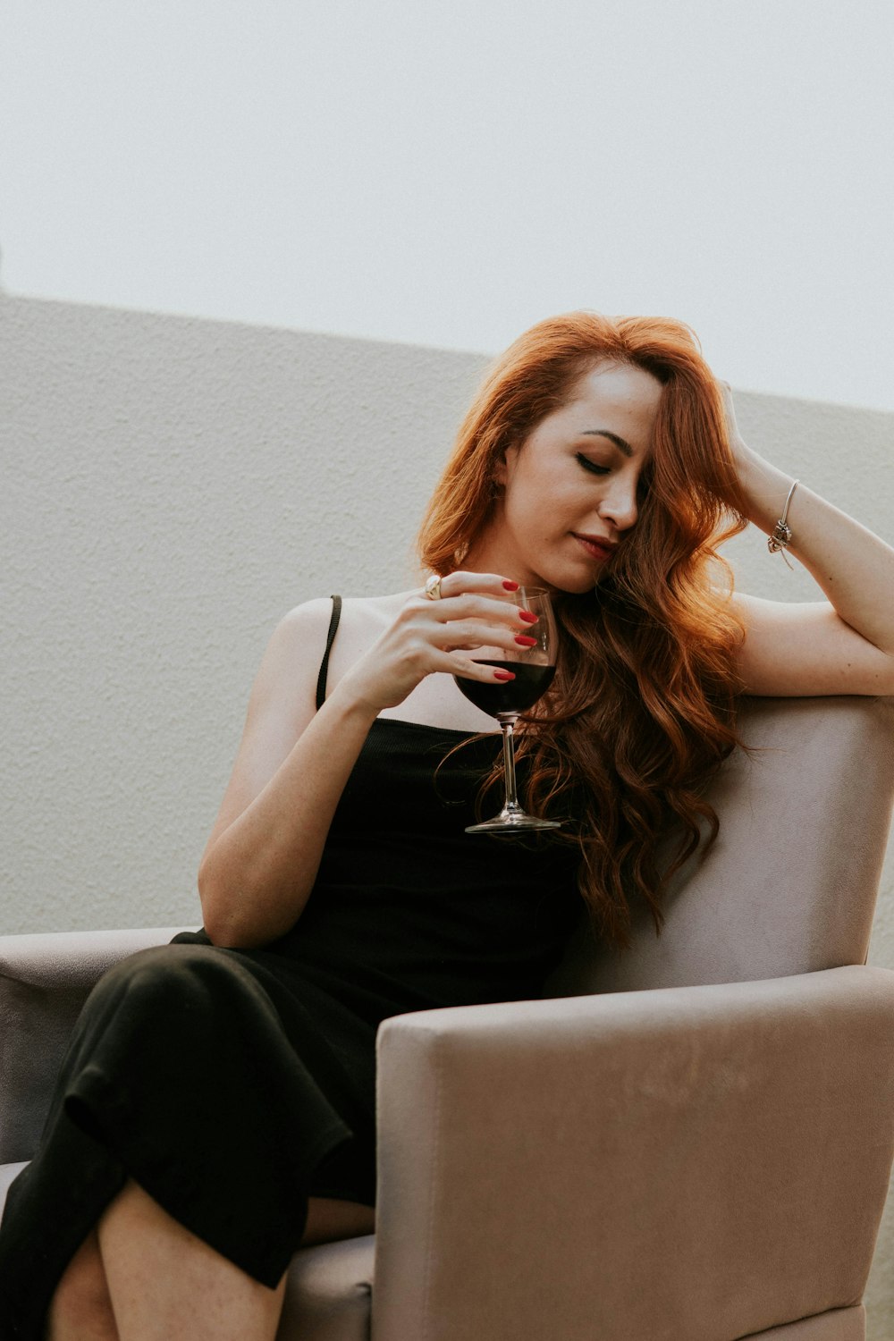 a woman sitting on a couch holding a glass of wine