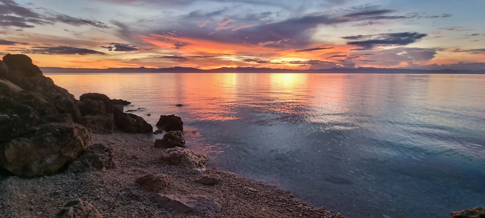 a rocky beach with a sunset