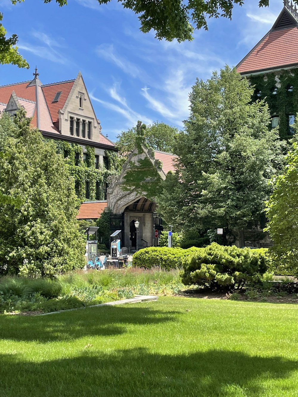 a large building with a lawn and trees in front of it