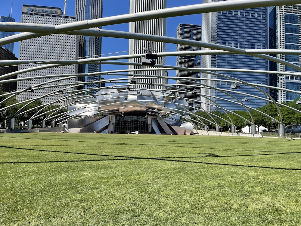 a large glass building with a green lawn in front of it