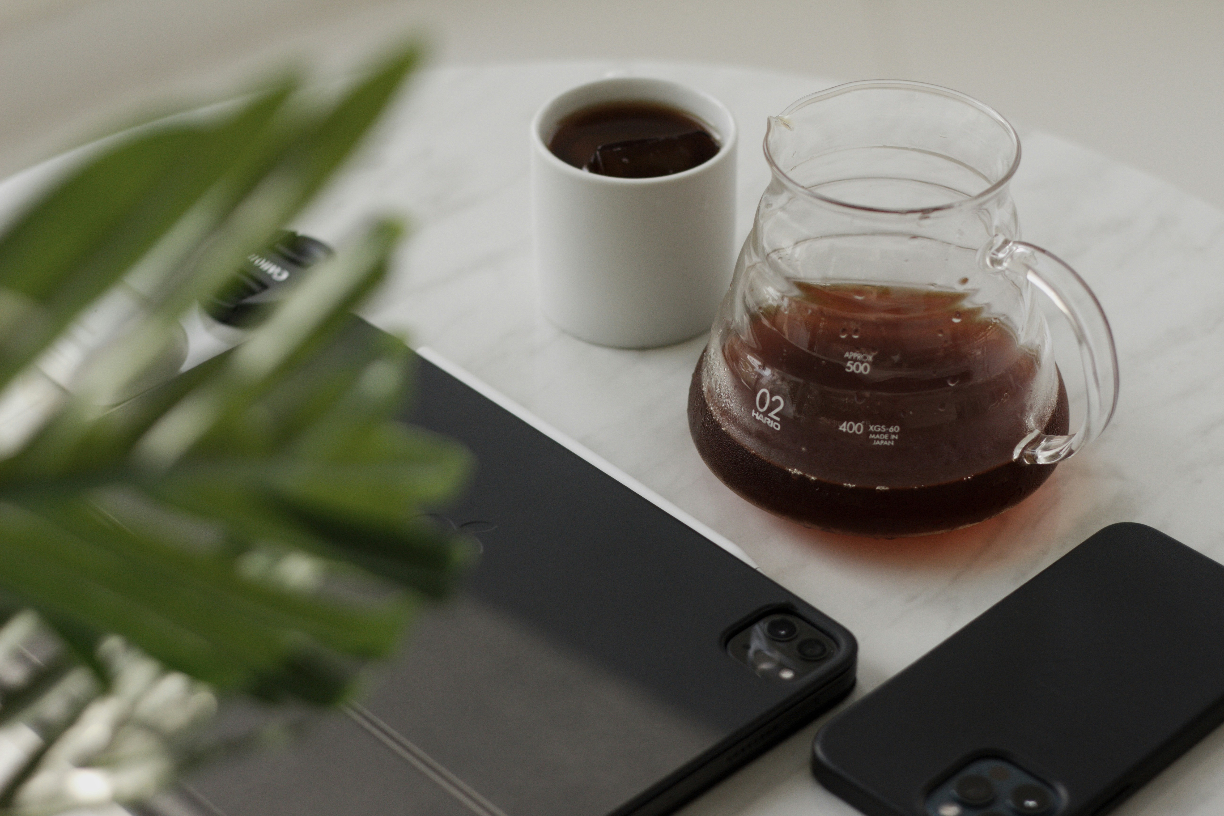 a glass of liquid next to a glass of liquid and a cell phone