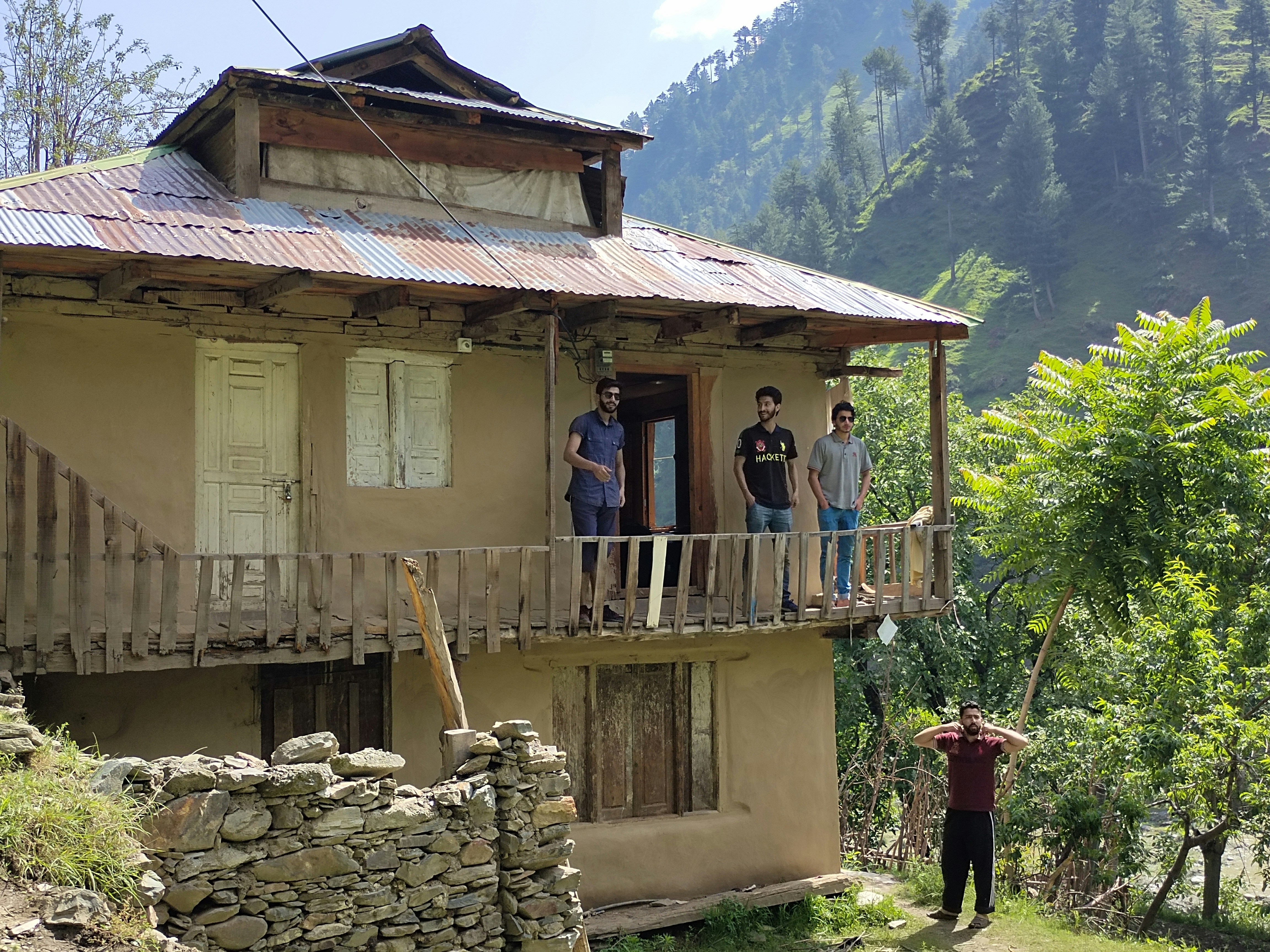a group of people standing on a wooden porch of a house