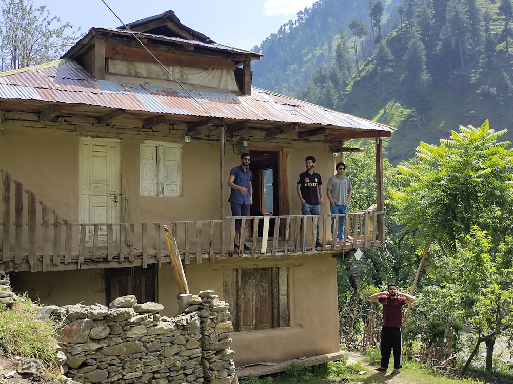 a group of people standing on a wooden porch of a house