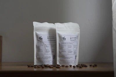 Minimalist flat lay of premium coffee seeds and tea packages on a warm beige background.