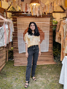 Display of earthy-toned bohemian jackets and shirts hanging against a weathered wooden backdrop.