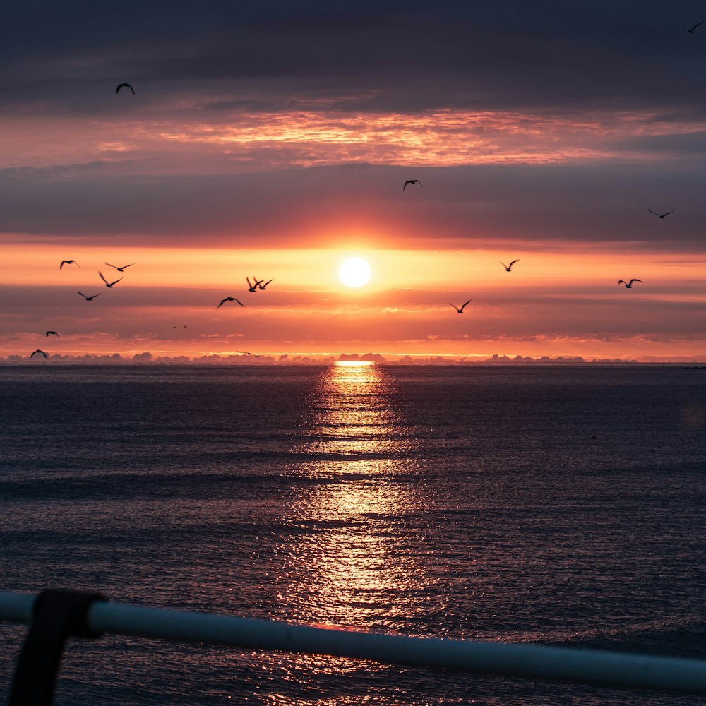 a sunset over a body of water with Sunset Beach in the background