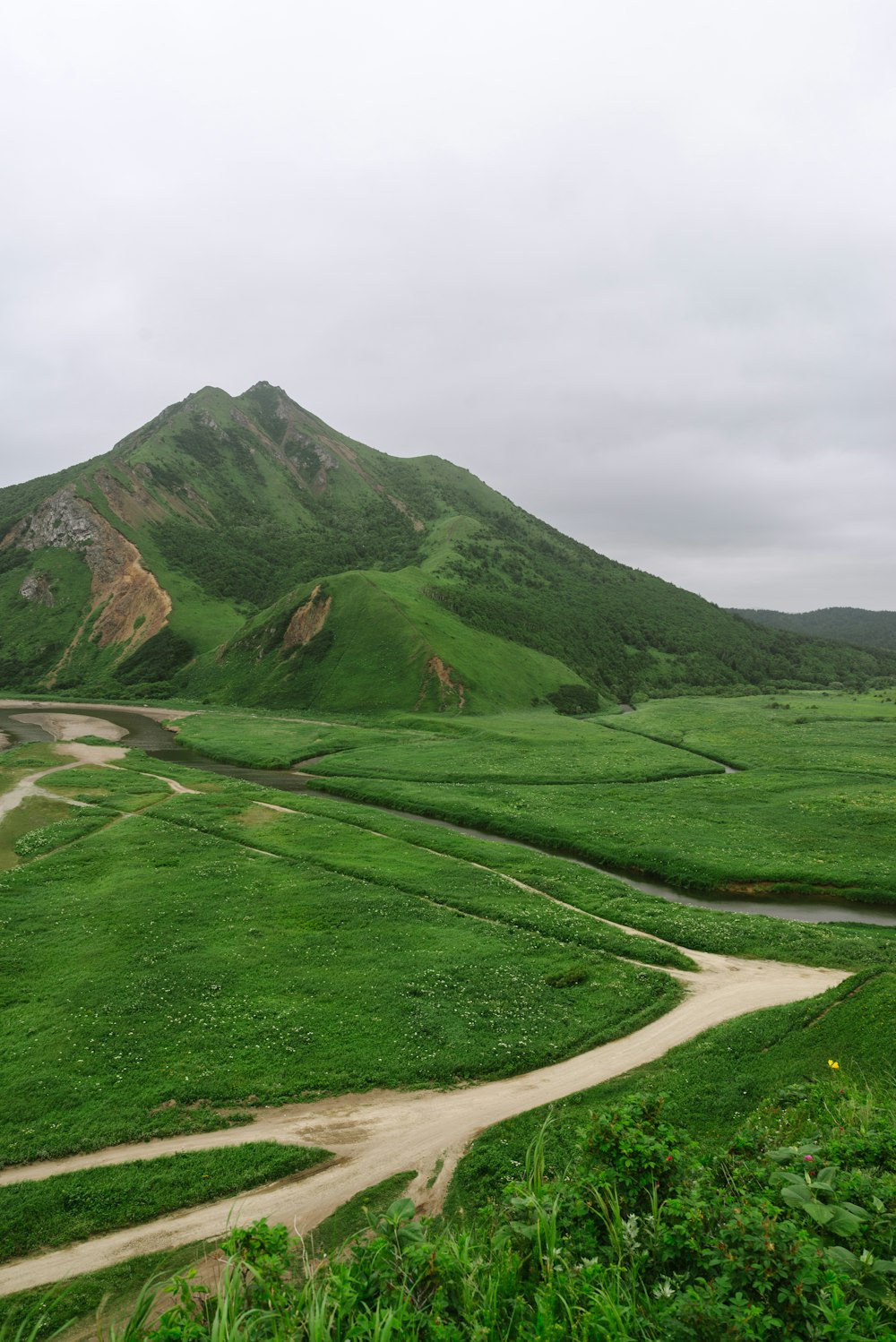 a green valley with a dirt road