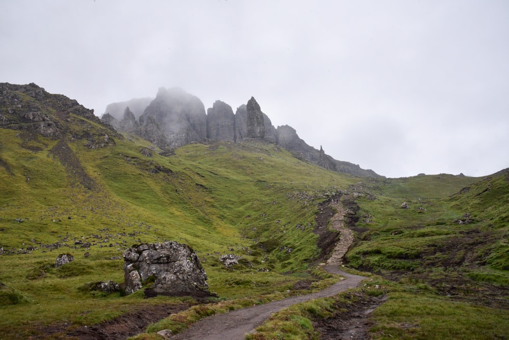 a dirt road on a grassy hill