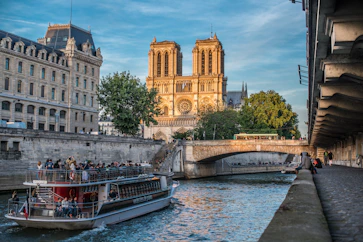 A boat cruising down the River Seine in front of the Notre Dam Cathedral