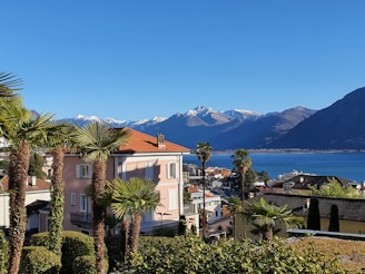 a building with trees and a body of water in the background