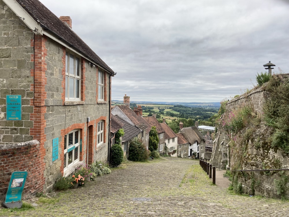 a stone road between brick buildings