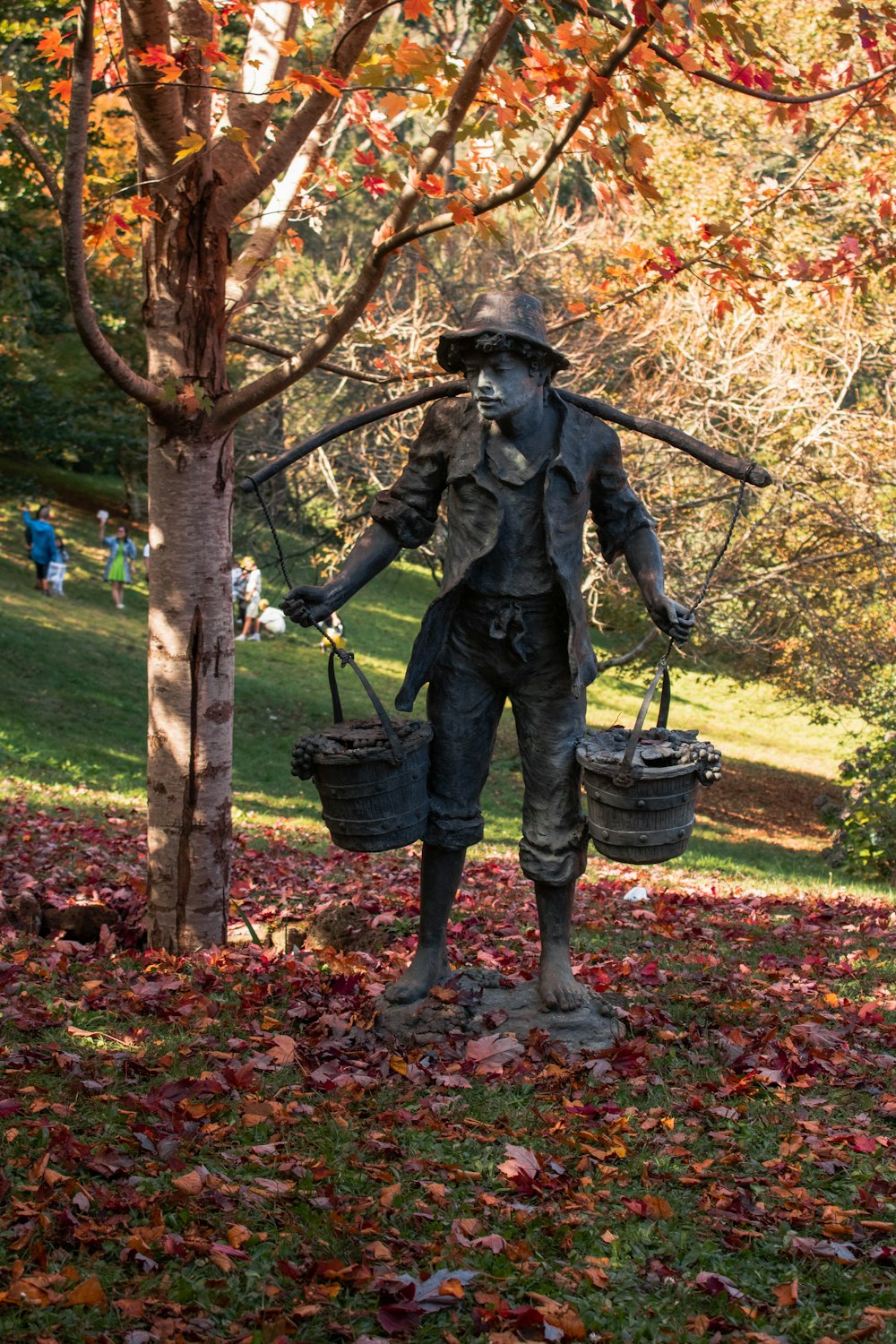 a statue of a person holding a bucket and a bucket