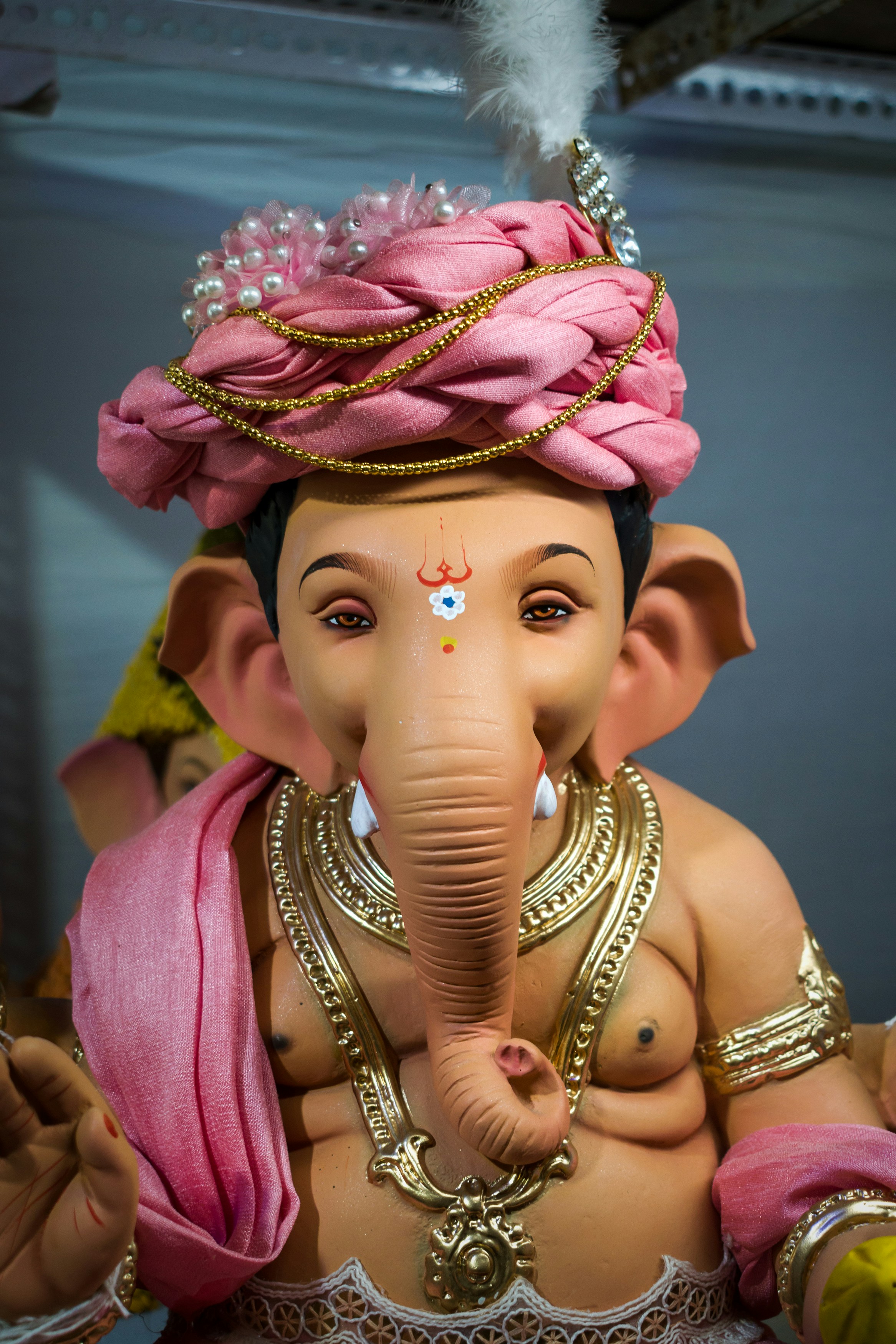 Eine Person trägt einen bunten Kopfschmuck und einen bunten Hut