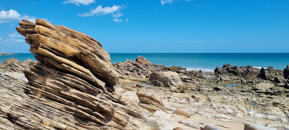 a rocky beach with a large stack of rocks