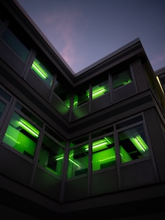Evening shot of a green building lit softly with energy-efficient lighting