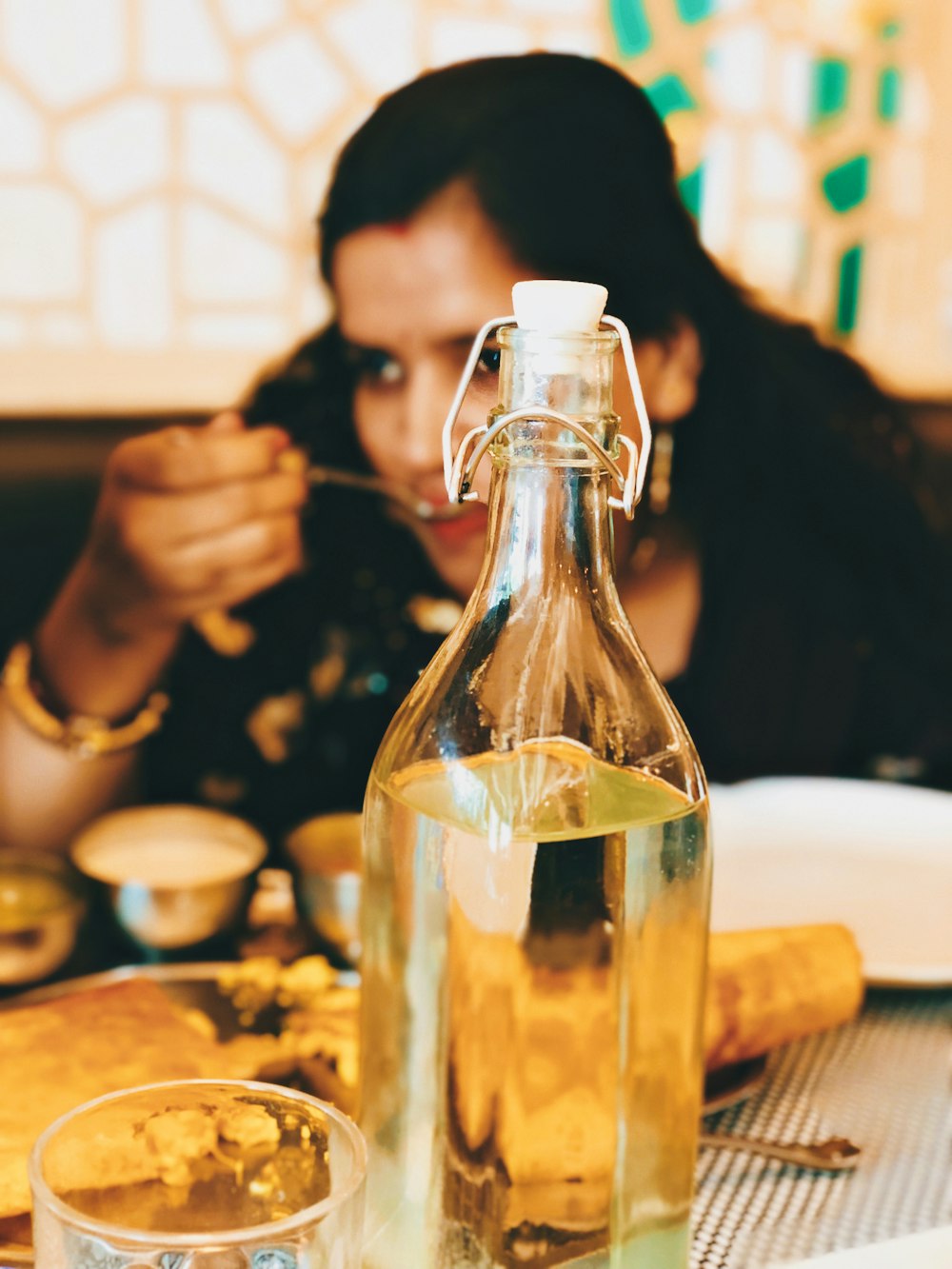 a person pouring a liquid into a glass bottle