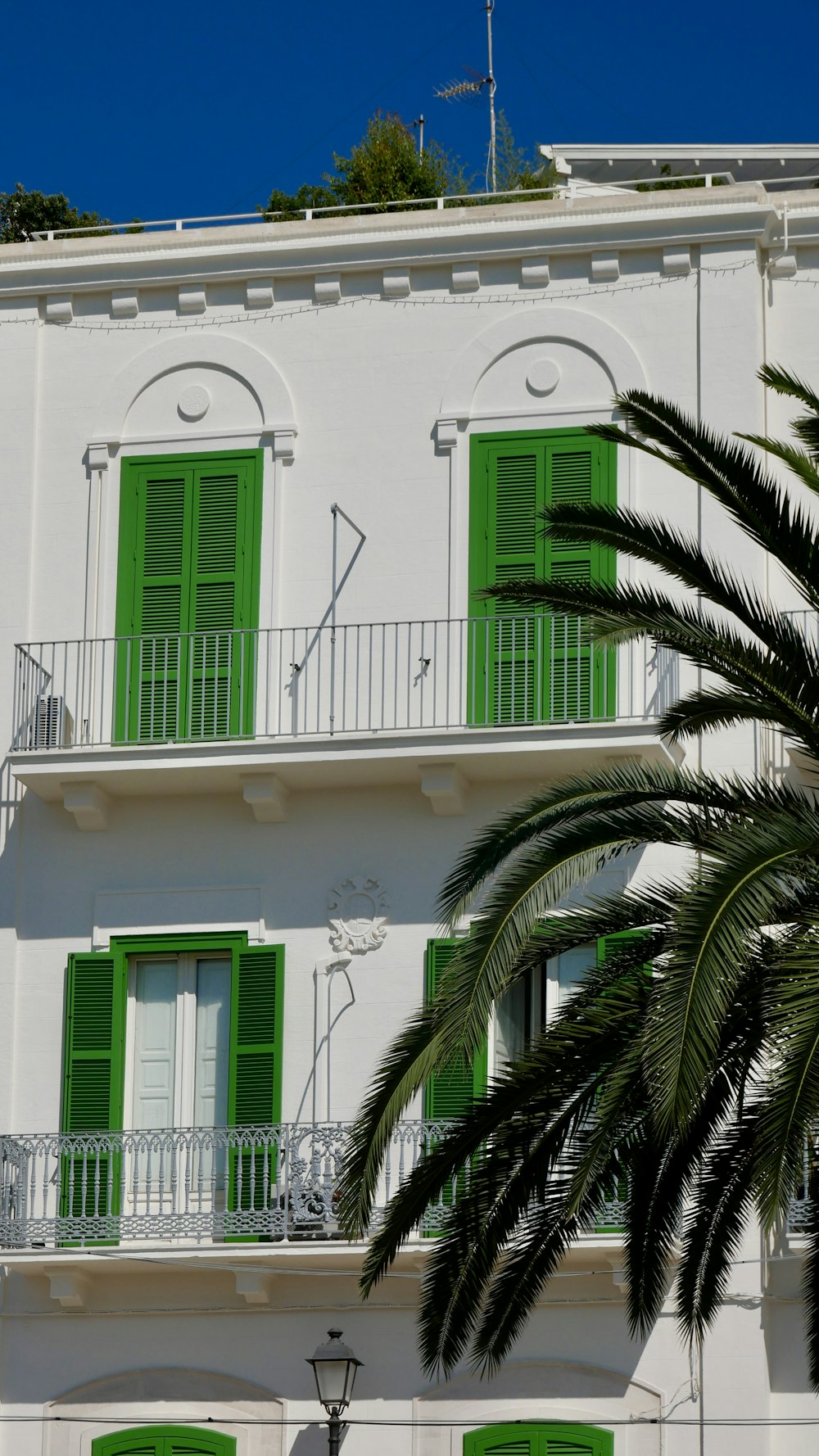 Un edificio blanco con persianas verdes