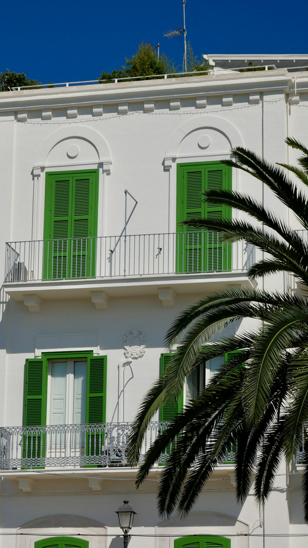 um edifício branco com persianas verdes