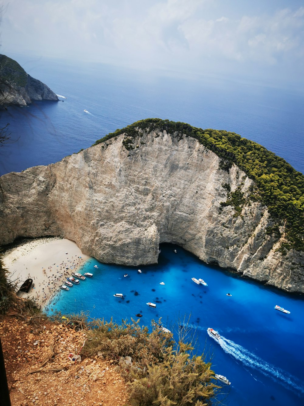 a rocky cliff with a body of water below