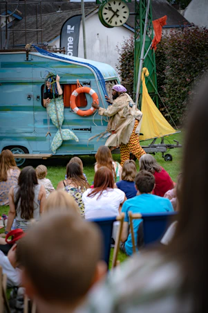 a group of people watching a person play a musical instrument