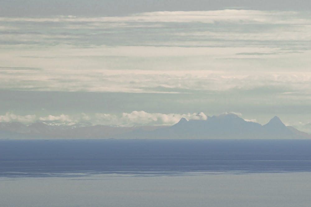 a body of water with mountains in the distance