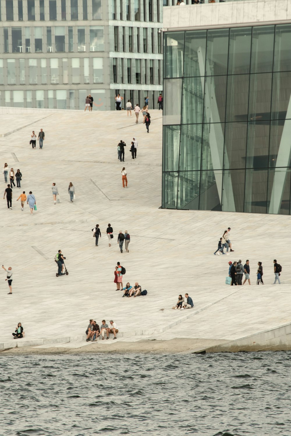a group of people standing around a large glass building