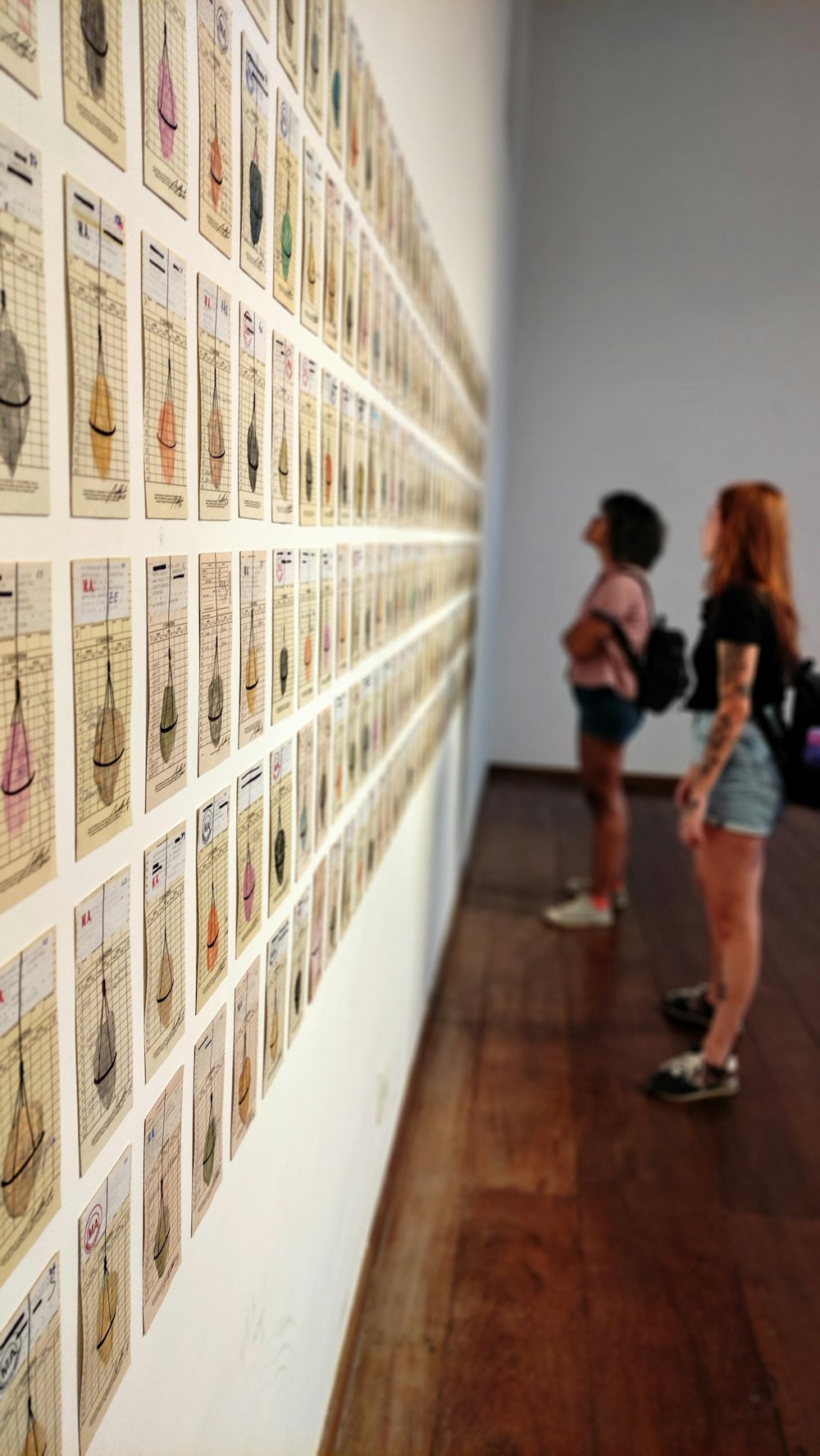 a group of people looking at a wall of photographs