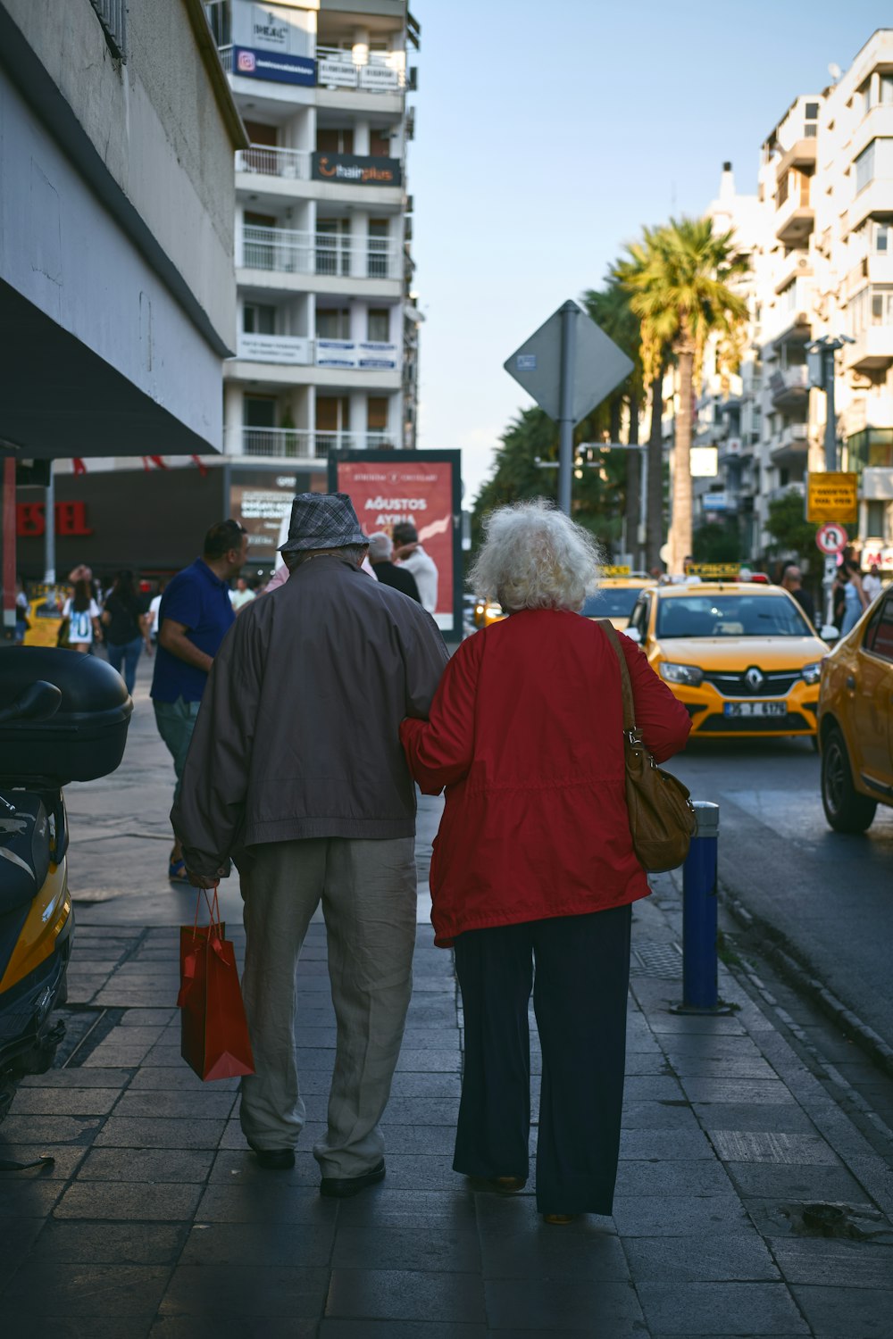 a couple of people walking down a sidewalk