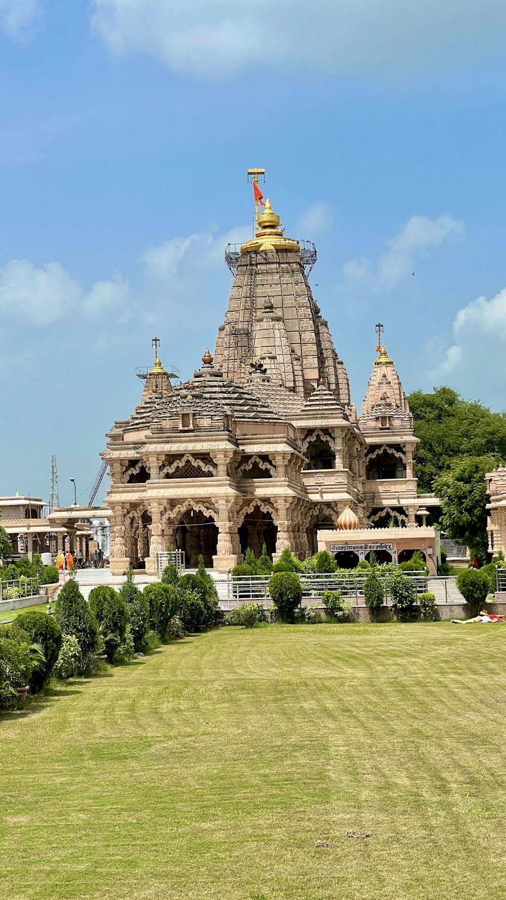 a large building with a grass lawn with Ananda Temple in the background