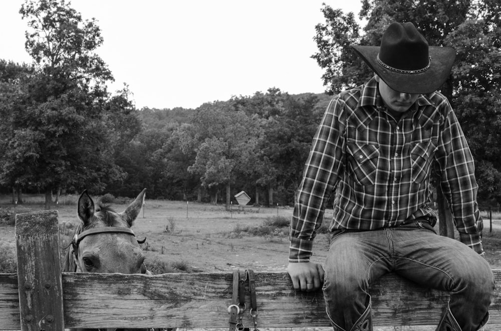 a man and a donkey by a fence