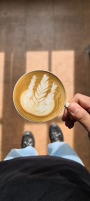 A cozy scene featuring a person wearing fashionable shoes and holding a coffee cup, capturing everyday style.