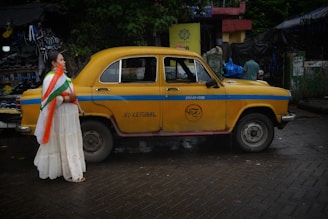 a person standing next to a yellow car