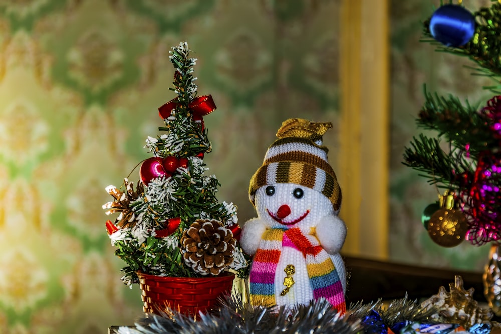 a snowman next to a christmas tree