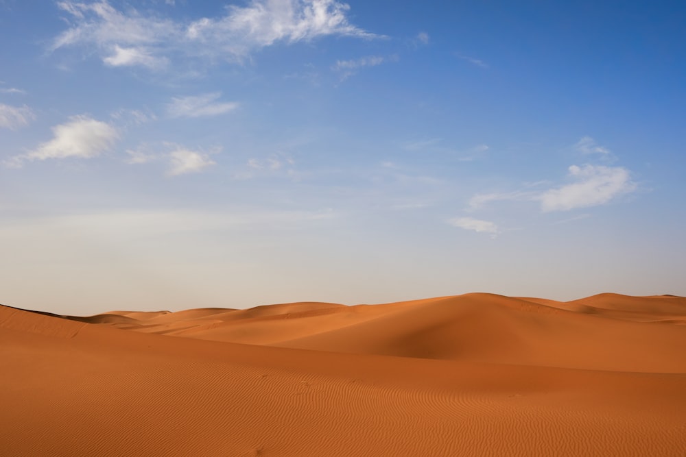 a desert landscape with blue sky and clouds