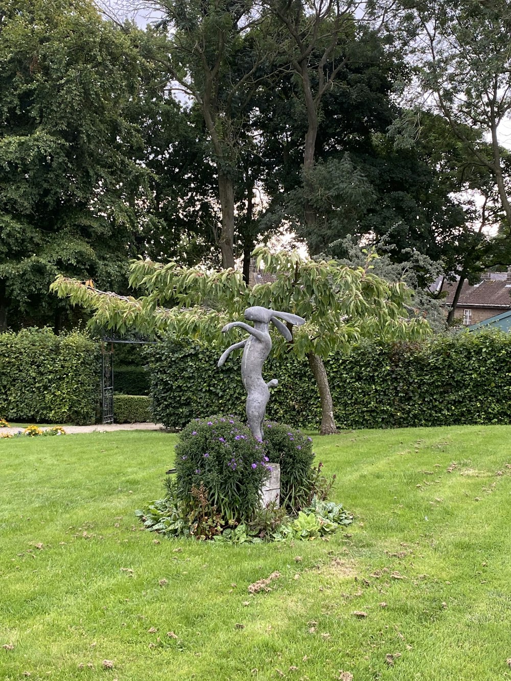 a statue of a cat in a garden
