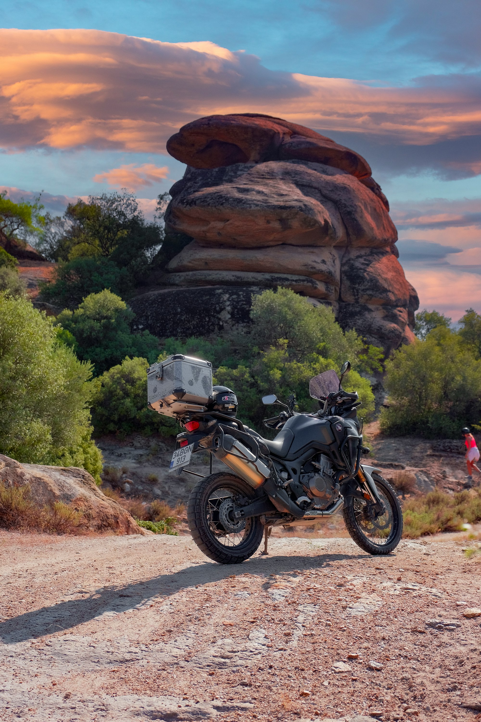 a motorcycle parked in front of a large rock formation