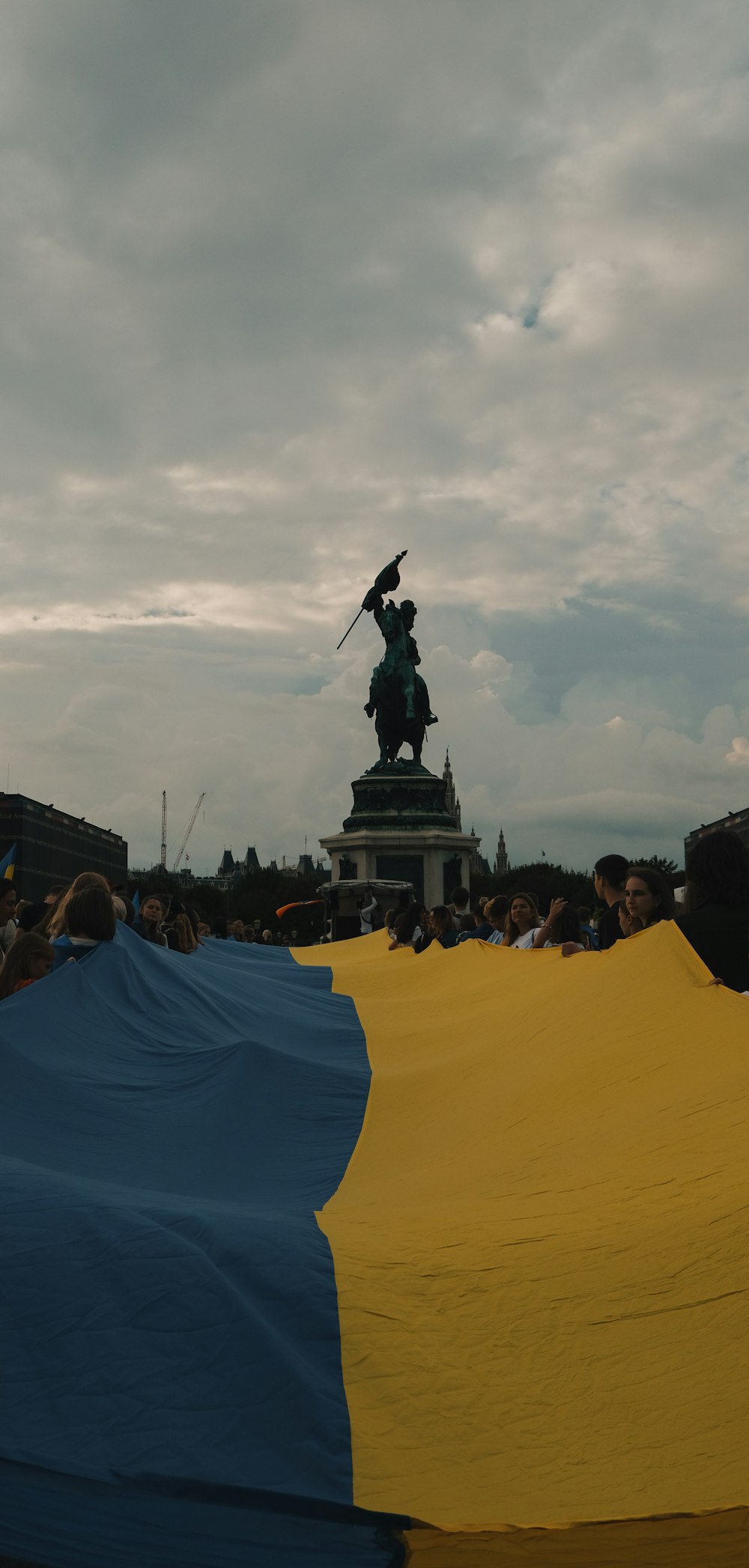 a statue of a person holding a torch in front of a crowd