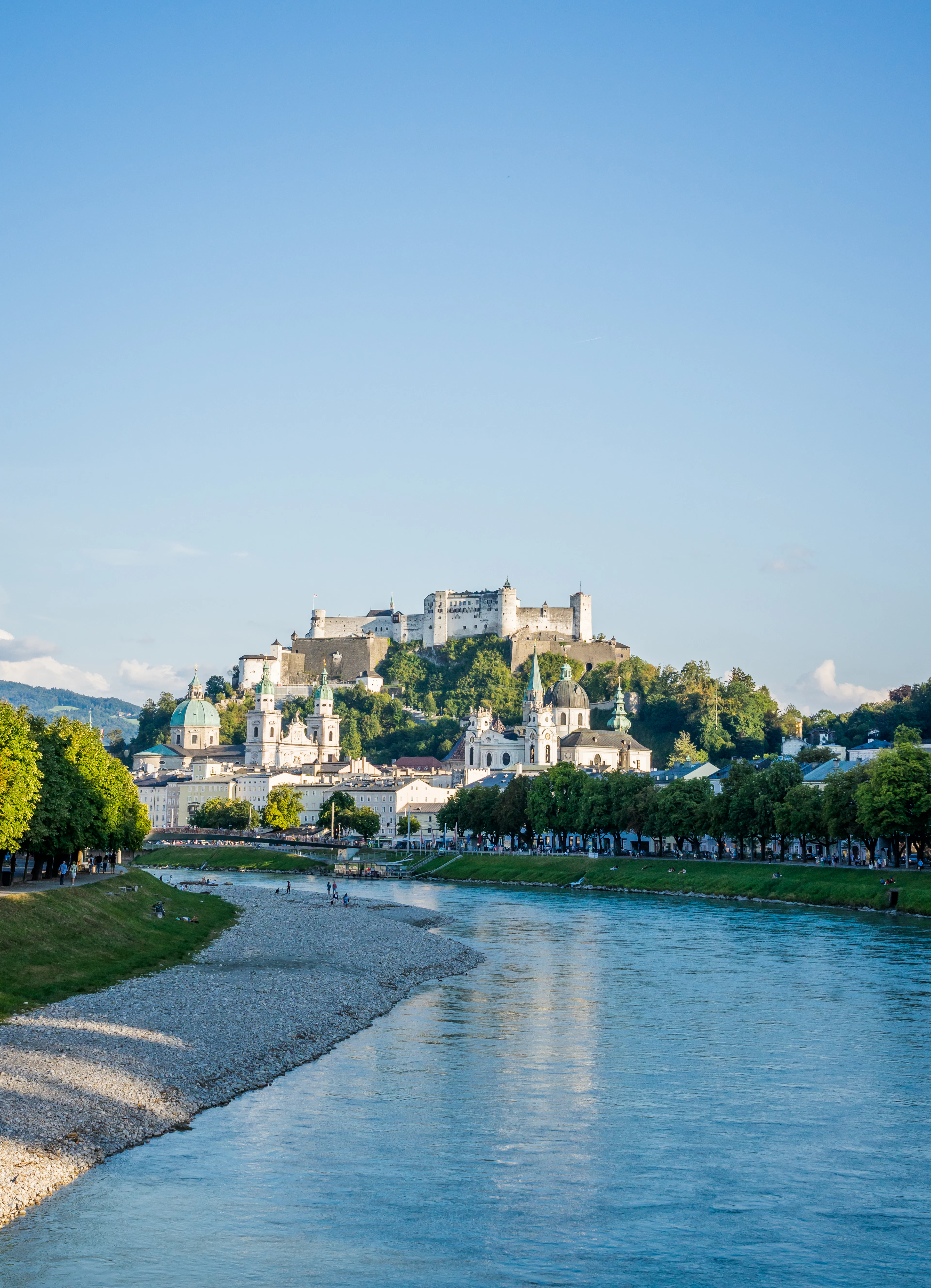 Salzach river at golden hour with Hohensalzburg Fortress crowning the hill above Salzburg's old town.