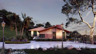 A modern house with a sloped red tile roof surrounded by lush green trees and landscaping. The house features large windows and a well-maintained garden area. A driveway leads up to the house with vintage-style street lamps lining the path.