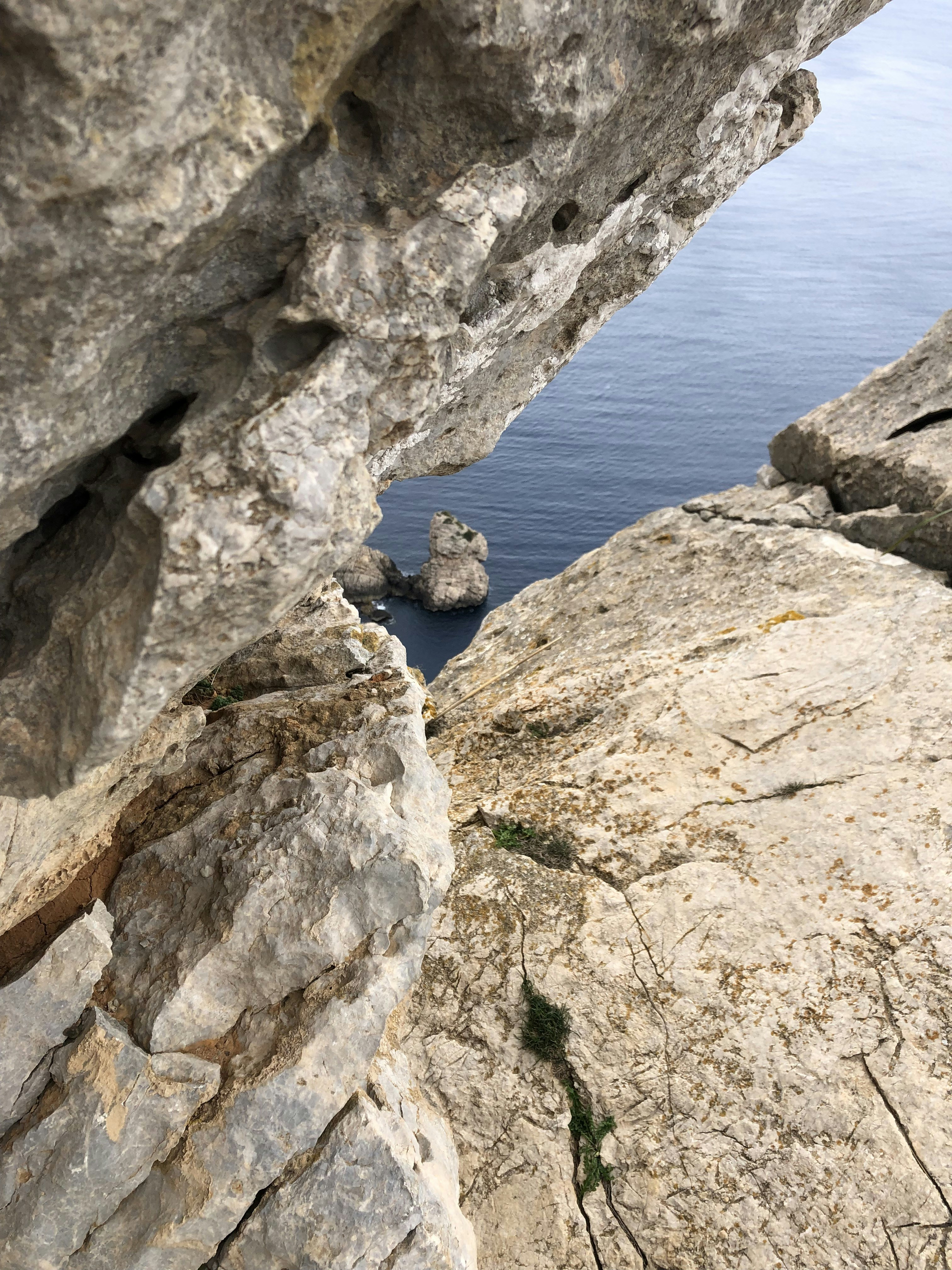 a cliff side with a body of water in the background