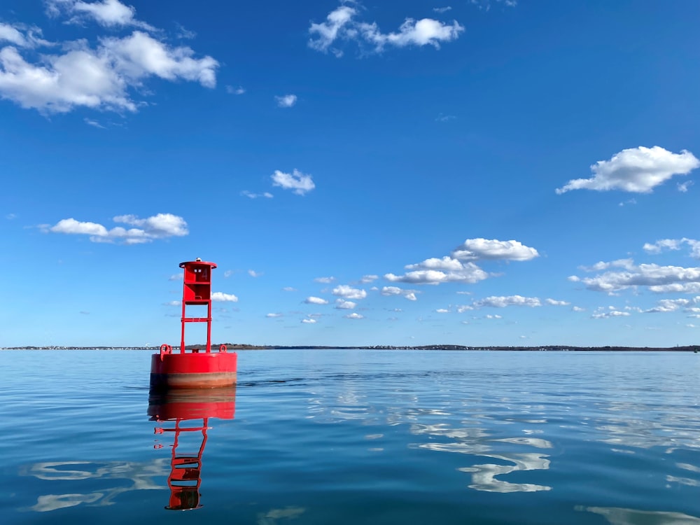 a red tower in the middle of a body of water