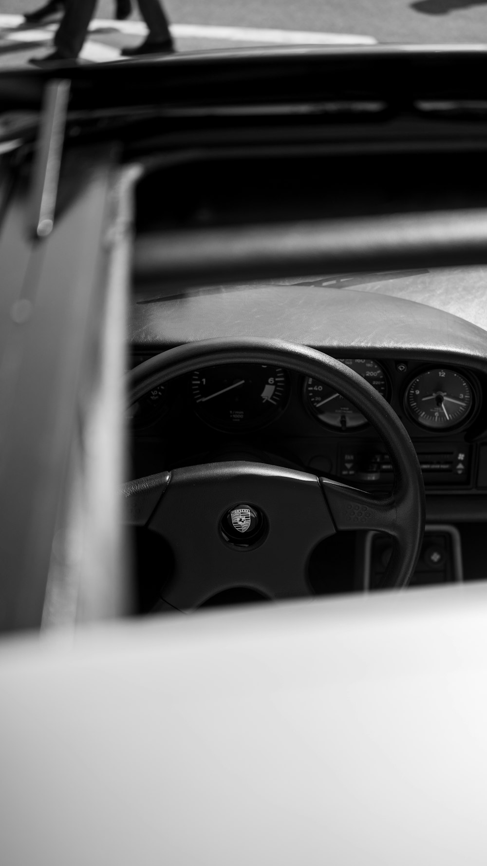 a car dashboard with a black steering wheel and a white background