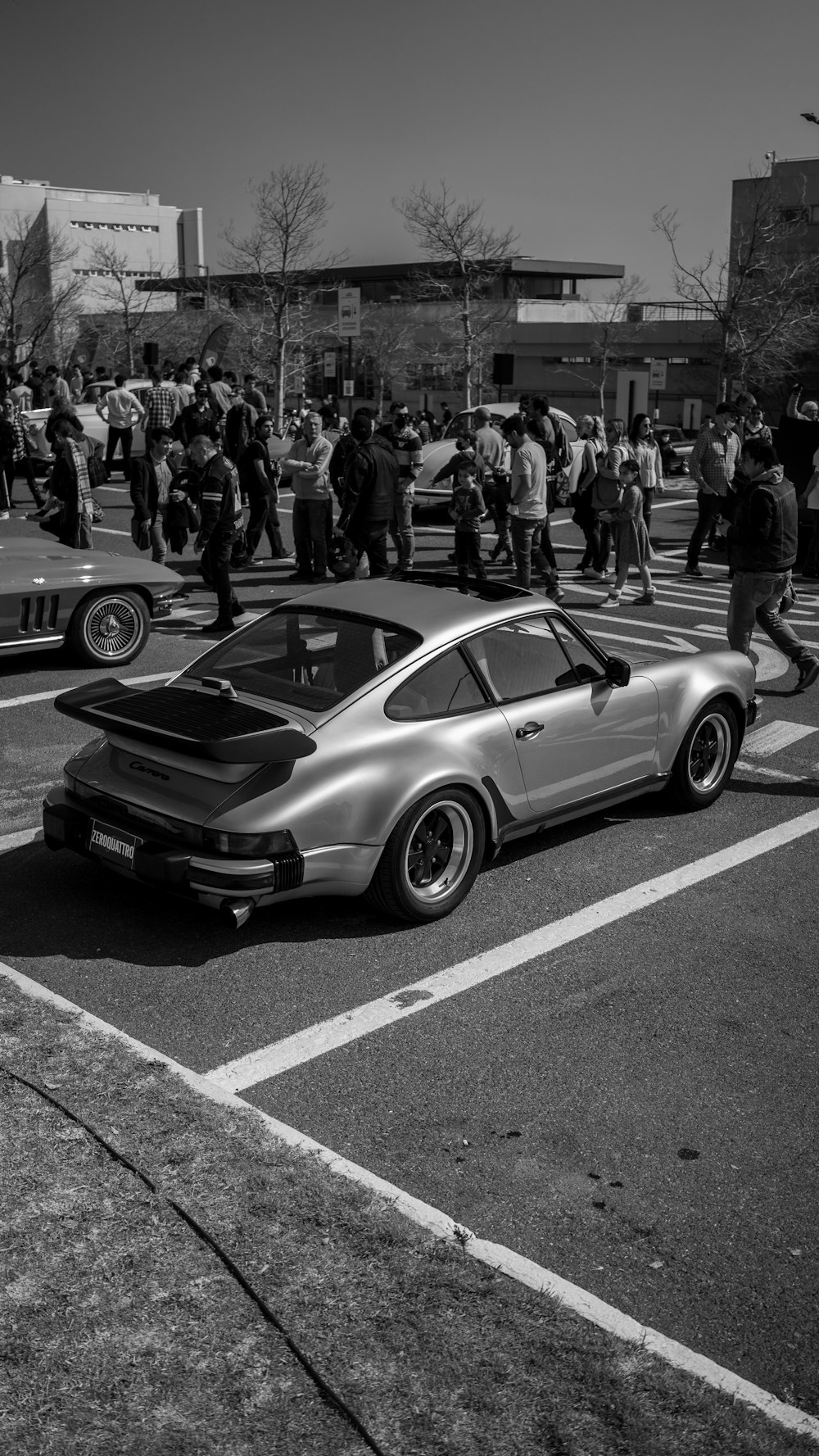 a car on the road with a crowd watching