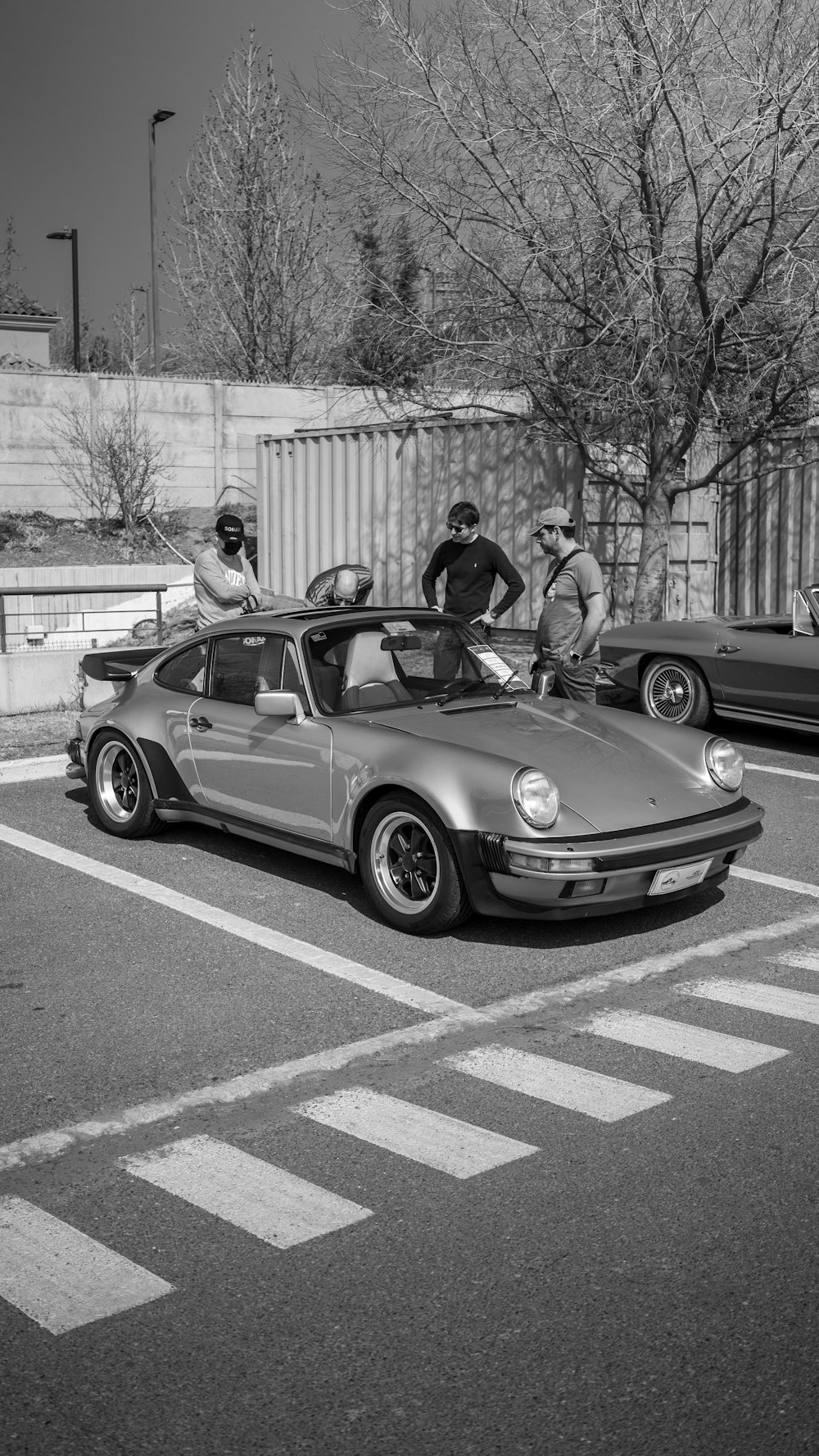 a group of men standing next to a car