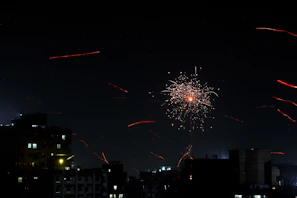 Festive fireworks bursting in the night sky over a lively city celebration